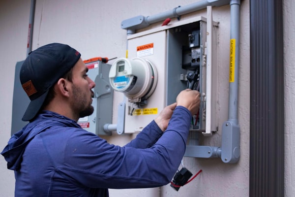 Electrician inspecting residential electrical meter and panel